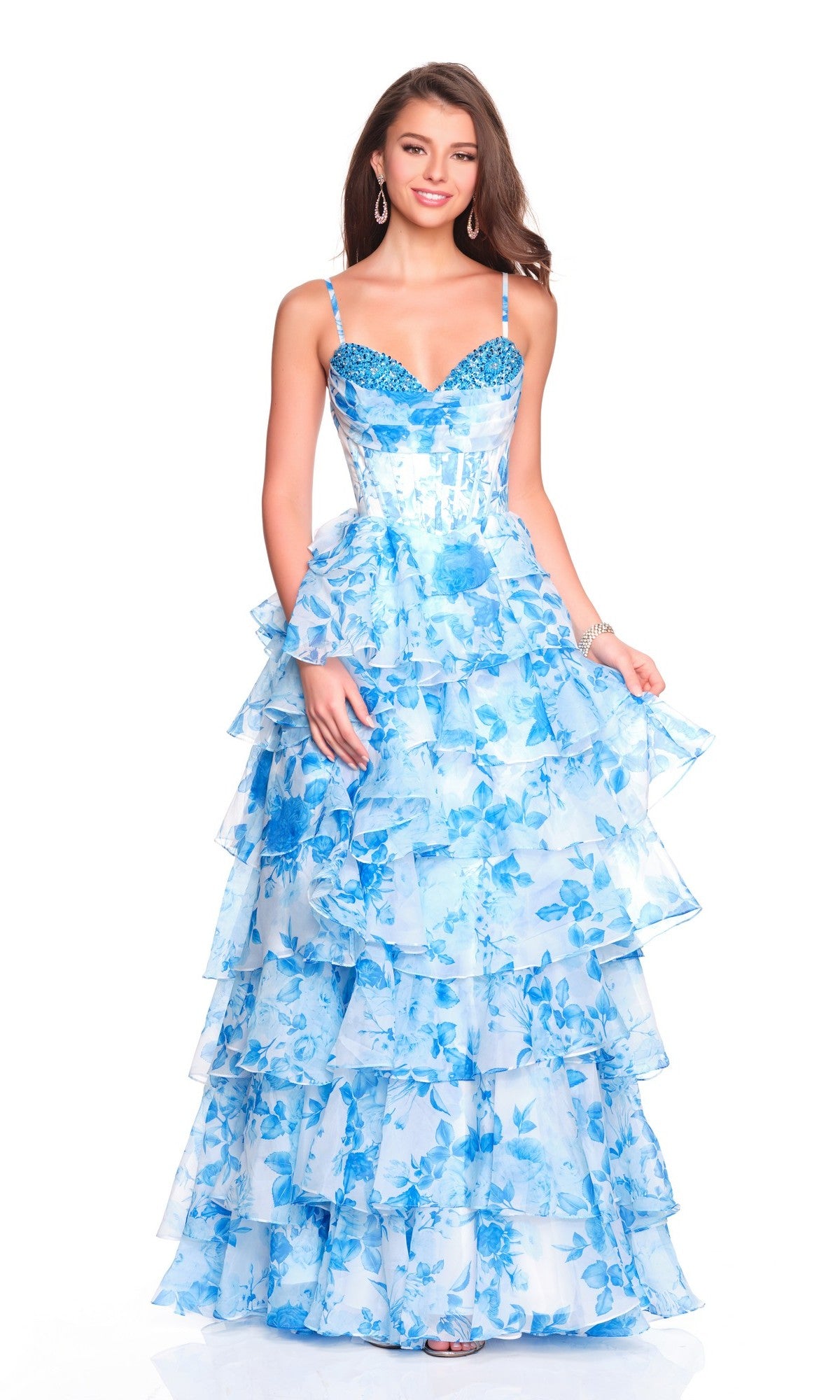 A woman poses and smiles against a white background wearing the Dave and Johnny 12809 long prom dress with a blue corset bodice and tiered ruffle chiffon skirt.